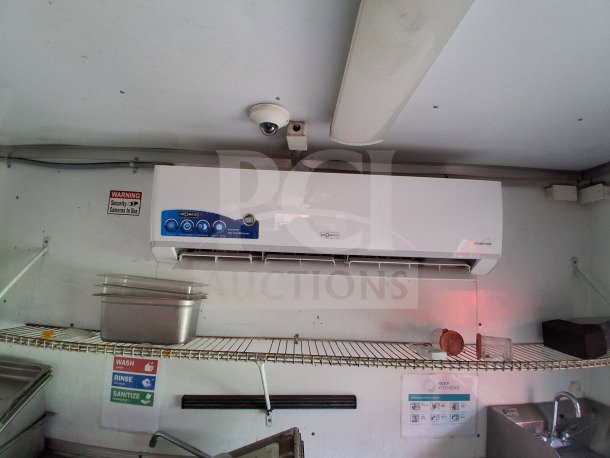 Interior view of D&A Custom 2019 mobile kitchen, showing air curtain unit, shelves with kitchenware, and sanitation signage.