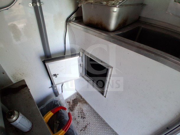2019 D&A Custom mobile kitchen interior, showing stainless steel sink and equipment storage area.