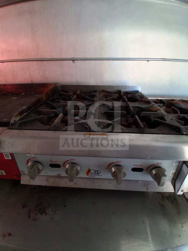 Interior of the 2019 D&A Custom Mobile Kitchen showing a CPG stovetop with four burners and control knobs.