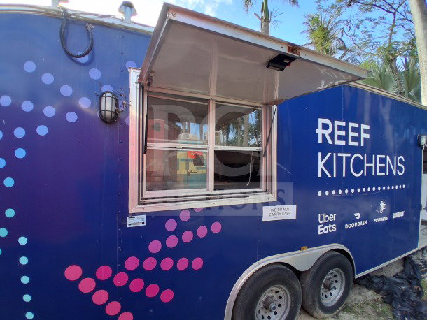 2019 D&A Custom 24ft mobile kitchen trailer with dark blue wrap, service window, and branded signage.