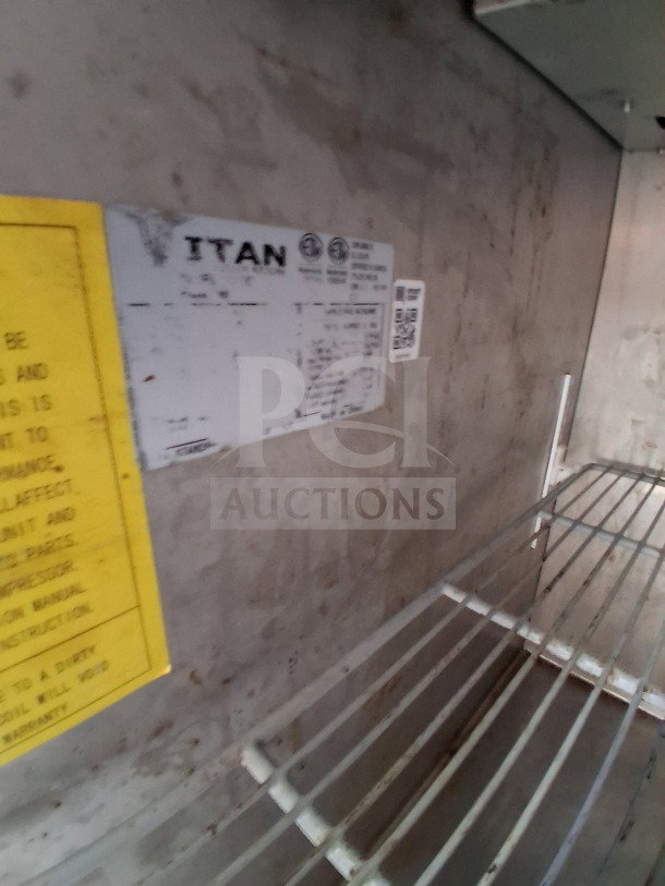 Interior view of a 2019 D&A custom mobile kitchen trailer. Visible are metal shelves and a manufacturer's label marked "Titan."