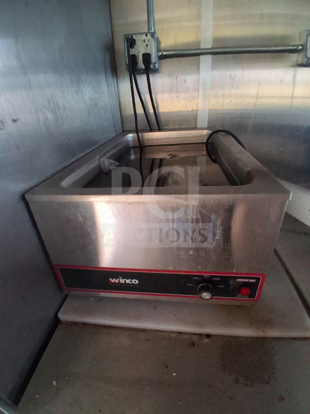 Winco countertop food warmer in Diamond Cargo mobile kitchen, requires cleaning, visible electrical outlet above.