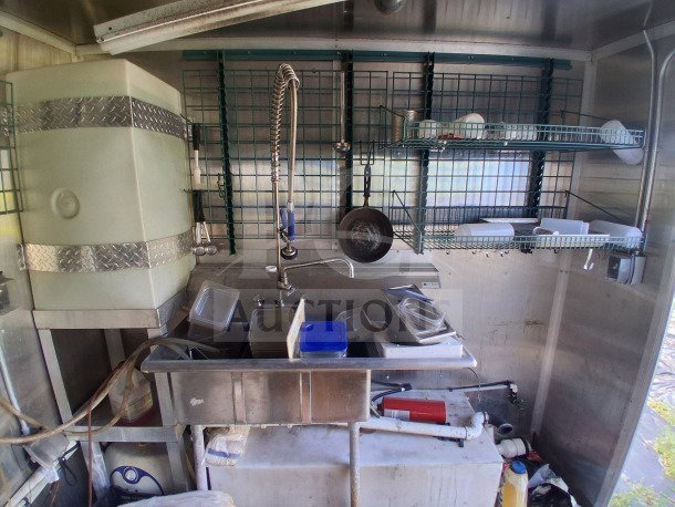 2019 Diamond Cargo 24' mobile kitchen interior with stainless steel sink, storage racks, and equipment; needs deep cleaning.