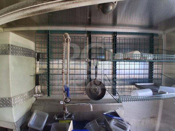 2019 Diamond Cargo 24' mobile kitchen interior; features ventilation, shelving, and sink. Requires thorough cleaning.