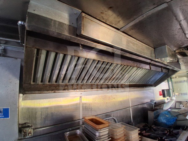 2019 Diamond Cargo 24' mobile kitchen interior, showing ventilation hood above professional cooking equipment. Requires deep cleaning.