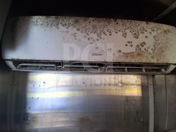 Dirty ZenAire air conditioning unit inside a 2019 Diamond Cargo mobile kitchen, requiring deep cleaning.