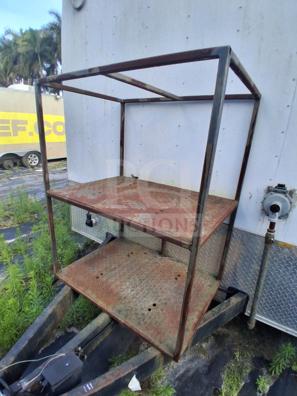 Rusted metal shelving unit attached to the side of a 2019 Diamond Cargo mobile kitchen trailer. Needs deep cleaning.