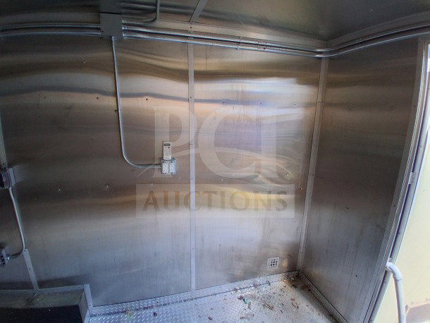 2019 Diamond Cargo 24' mobile kitchen interior with metal walls, visible electrical setup, and signs of mild dirt accumulation.
