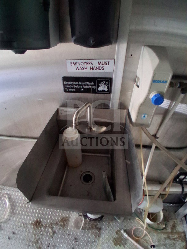 Hand sink in 2019 Diamond Cargo mobile kitchen with soap dispenser and "Employees Must Wash Hands" sign, requires cleaning.