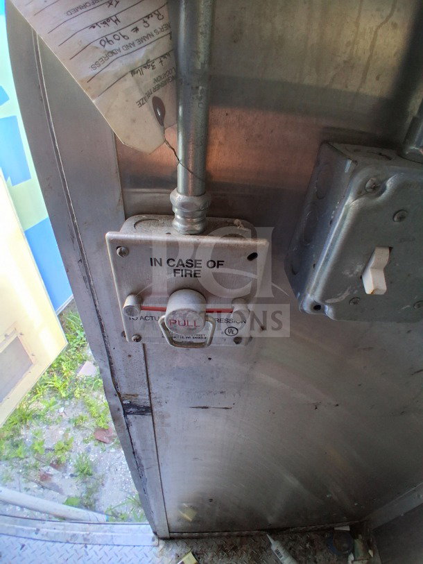 Fire suppression system handle in the 2019 Diamond Cargo 24' mobile kitchen. Visible wear, requires cleaning.