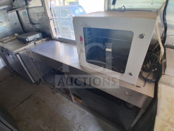 2019 Quality Cargo food trailer interior with stainless steel counters, grease hood, fryer, griddle, and refrigeration unit.