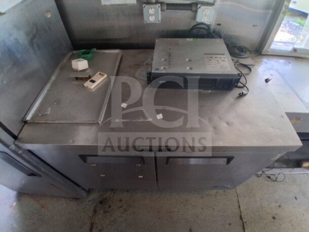 2019 Quality Cargo Food Trailer interior showing stainless steel countertop, electrical outlets, and a mounted APC device.