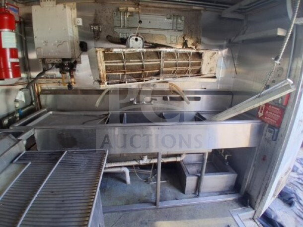 2019 Quality Cargo food trailer interior, showcasing commercial kitchen equipment including grease hood, fryers, griddle, and refrigeration.