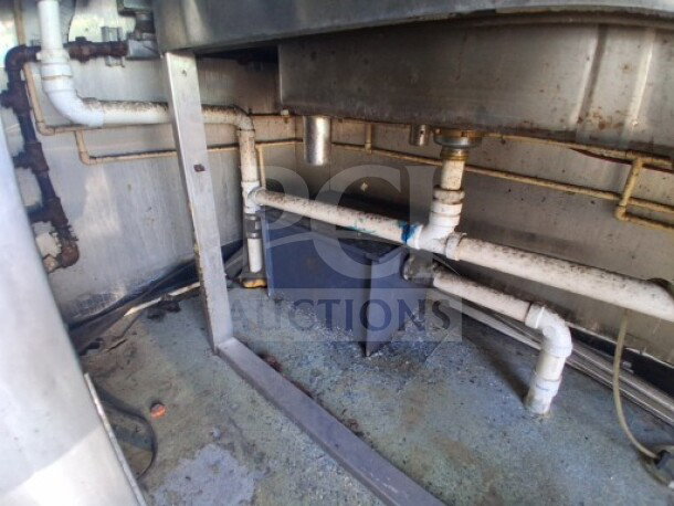 Under-sink plumbing of 2019 Quality Cargo Food Trailer, showing piping and grease trap. Suitable for commercial kitchen use.