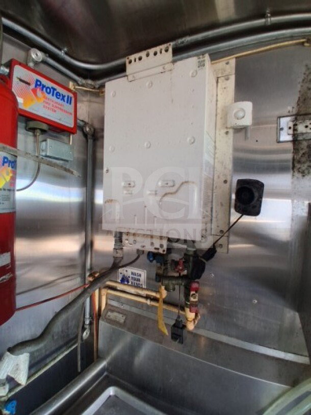 2019 Quality Cargo Food Trailer interior. Features include Protex II grease hood system, stainless steel surfaces, and plumbing.
