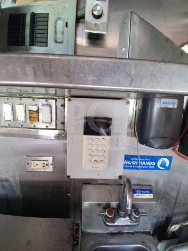 2019 Quality Cargo Food Trailer kitchen interior, showcasing control panel, outlets, soap dispenser, and sink.