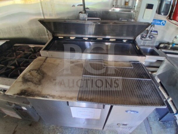 2019 Quality Cargo Food Trailer kitchen interior with griddle, grease hood, burner cooktop, and refrigeration suite.