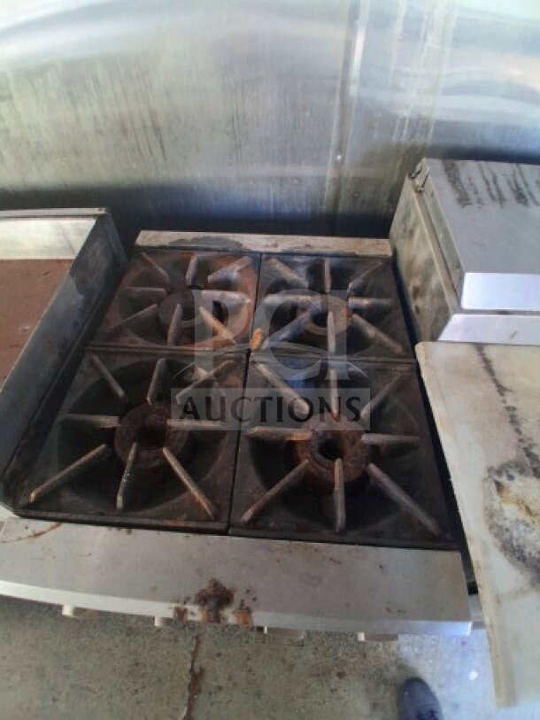 2019 Quality Cargo food trailer interior showing commercial-grade burner cooktop, slightly used condition, with grease stains.