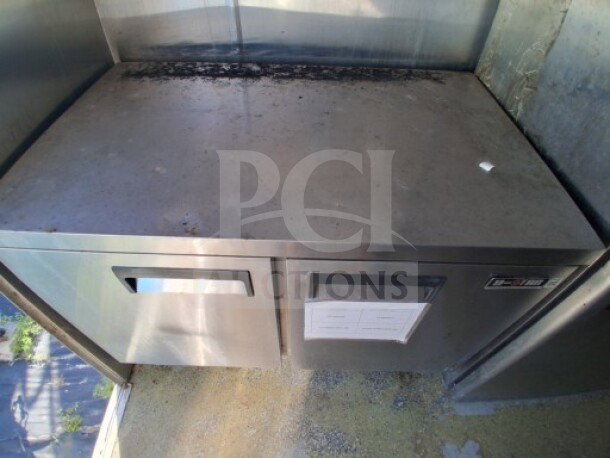 2019 Quality Cargo food trailer interior, stainless steel refrigeration unit. Features commercial-grade storage.