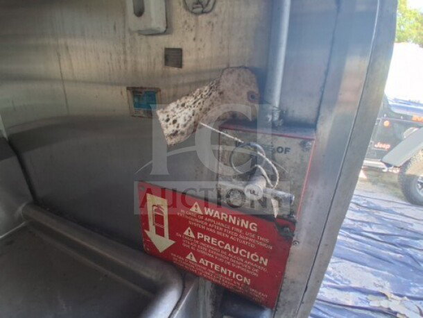 2019 Quality Cargo food trailer interior with visible warning signage, control panel, and stainless steel fixtures.