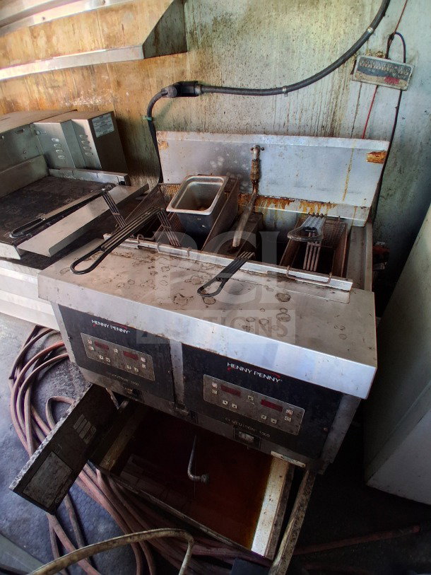 Henny Penny Double deep fryer with oil filtration drawer in a Freedom 20' food trailer, showing wear.