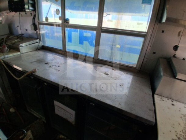 2018 Freedom 20' Food Trailer interior with service window, stainless steel counter, and refrigerated storage below.
