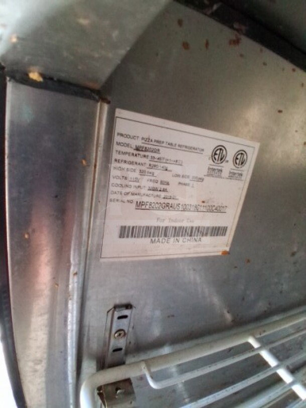 Label inside Freedom food trailer showing model and refrigeration specifications for Migali pizza/sandwich make line.