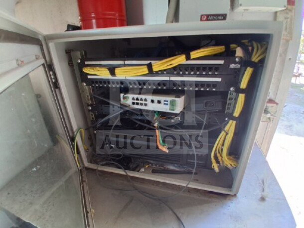 A network server rack with cables and switching equipment, housed in an open cabinet. Visible labels indicate "Aftronix".