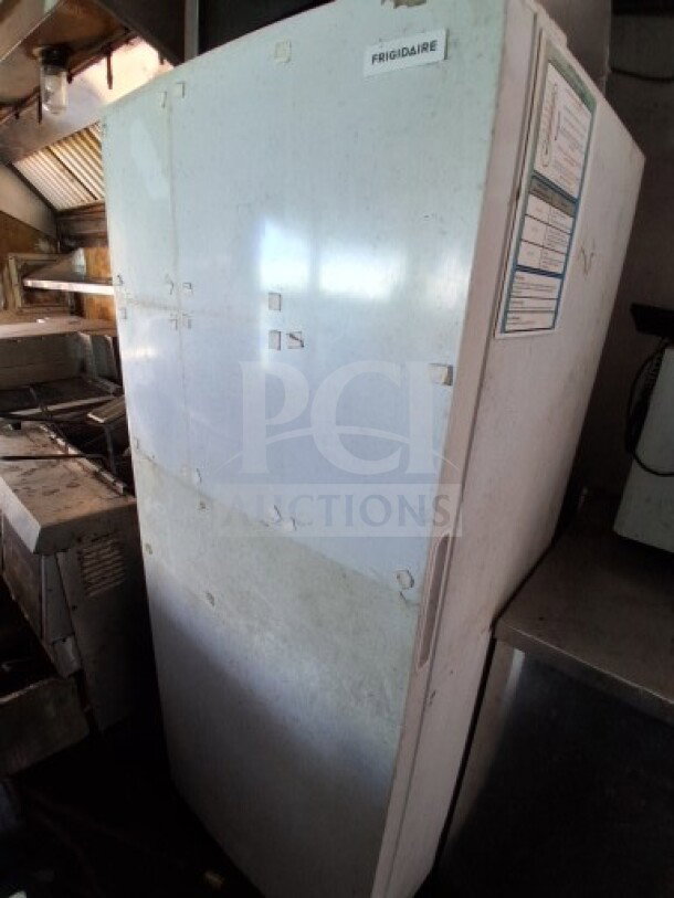 Frigidaire reach-in freezer inside 2018 Freedom 20' food trailer. Features ample storage space and visible wear.