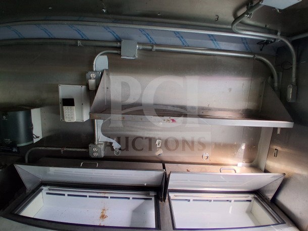 2021 Haulmark 8.5' x 24' Dual-Axle Mobile Kitchen Trailer interior with Arctic Air refrigeration units, shelving, and electrical setup.