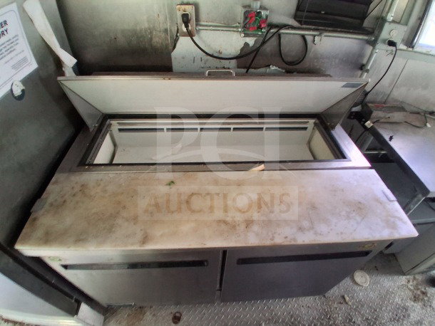 2021 Haulmark mobile kitchen interior with Arctic Air refrigeration unit, dual compartments, visible wear, and attached utility panel.