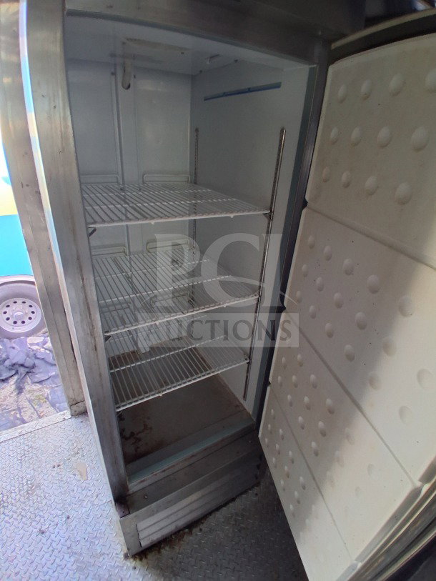 Open Arctic Air refrigeration unit inside a 2021 Haulmark 8.5' x 24' Dual-Axle Mobile Kitchen Trailer, showing shelving and clean interior.