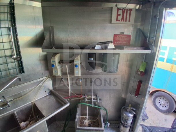 2021 Haulmark 8.5' x 24' mobile kitchen interior with Arctic Air refrigeration, commercial exhaust hood, fire suppression, and sanitation sink.
