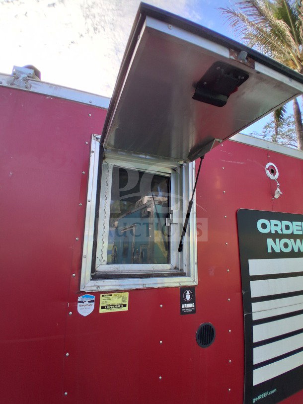 Red 2021 Haulmark 8.5' x 24' mobile kitchen trailer with serving window. Simplisafe and warning stickers visible.