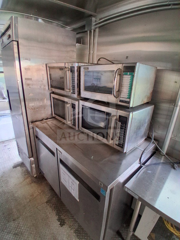 2021 Diamond Cargo 24' mobile kitchen interior, featuring stainless steel appliances, multiple microwaves, and Arctic Air refrigeration.