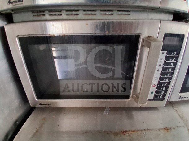Close-up of Amana commercial microwave in the 2021 Diamond Cargo 24' Custom Mobile Kitchen. Stainless steel, visible keypad.