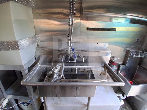 2021 Diamond Cargo 24' mobile kitchen interior. Features stainless steel sink, high faucet, and fire extinguisher.