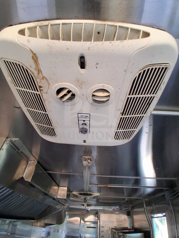 Interior view of a 2021 Diamond Cargo 24' Custom Mobile Kitchen, showing ceiling-mounted ventilation and stainless steel finish.