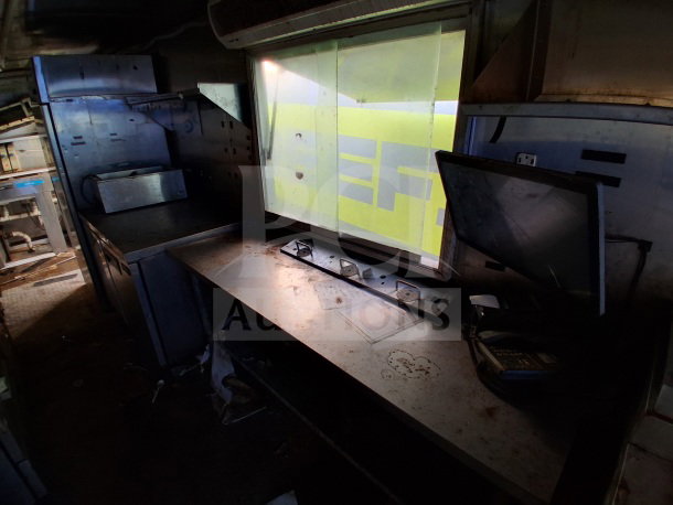 2019 Quality Cargo Food Trailer interior showing large order window, grease hood, dual fryers, griddle, and Atosa refrigeration.