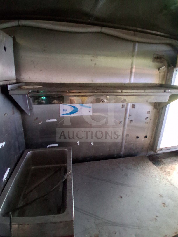 Interior view of 2019 Quality Cargo Food Trailer. Features stainless steel surfaces and fixtures, showing wear typical of use.