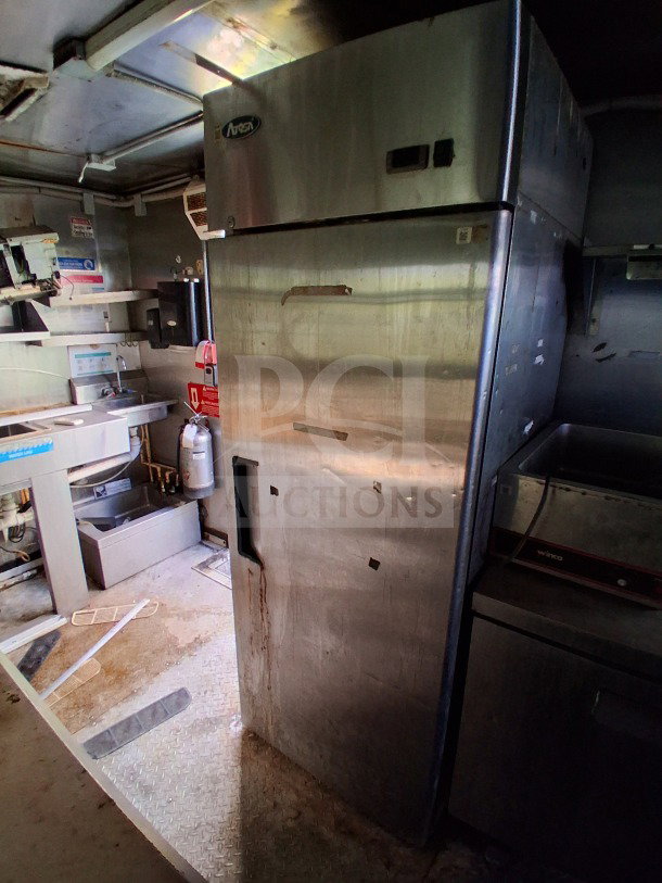2019 Quality Cargo Food Trailer interior with Atosa refrigerator, grease hood, fryers, griddle, and cooktop. Commercial kitchen setup.
