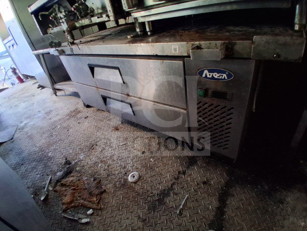 2019 Quality Cargo food trailer interior, featuring Atosa refrigeration equipment. Visible grease and dirt on diamond plate floor.