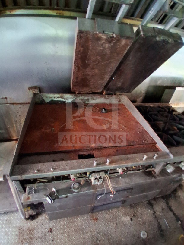 2019 Quality Cargo food trailer interior showing worn griddle and burner cooktop. Includes vents and control knobs.