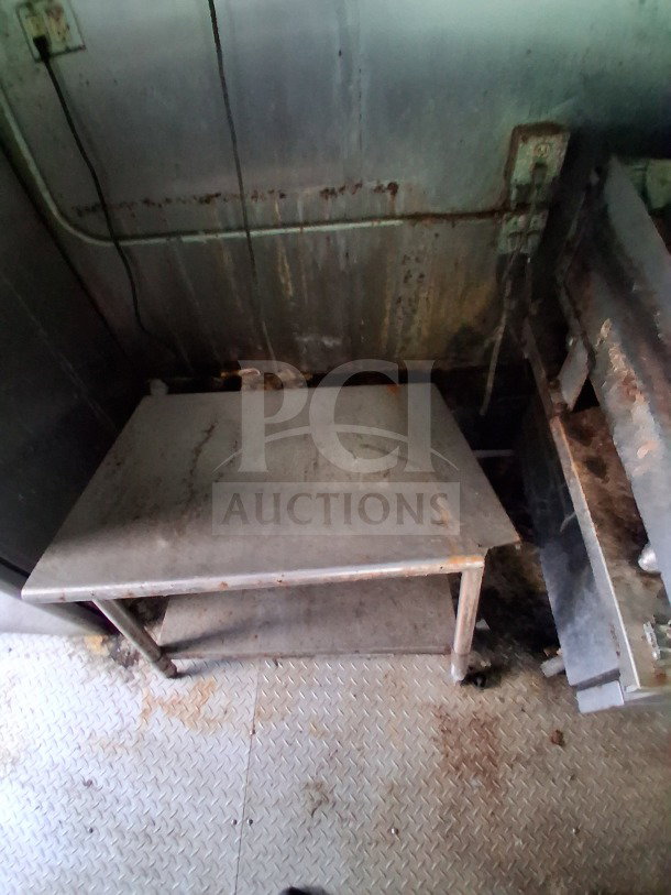 2019 Quality Cargo Food Trailer interior. Stainless steel table, visible wear. Commercial kitchen equipment included.