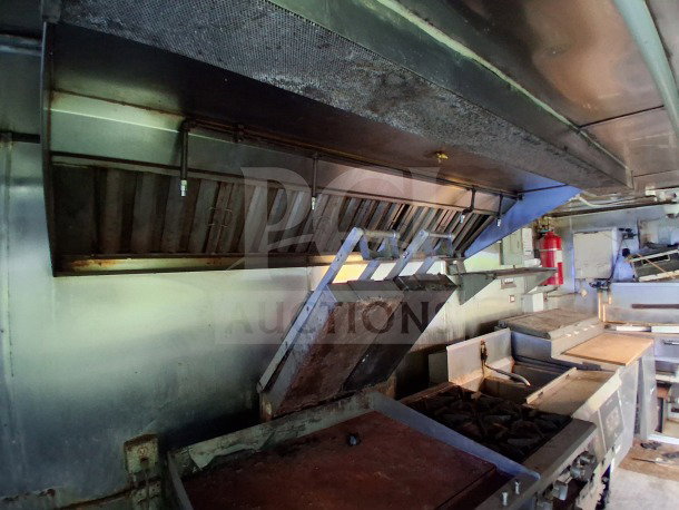 2019 Quality Cargo food trailer interior with grease hood, dual fryers, griddle, burner cooktop, and Atosa refrigeration.