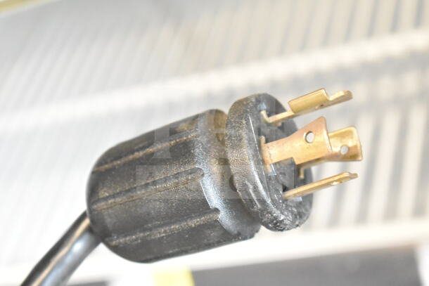 Close-up of power plug for 2020 True GDM-72F-HC commercial freezer, showing prongs and wear. Model rated 115/208-230V, 1 Phase.