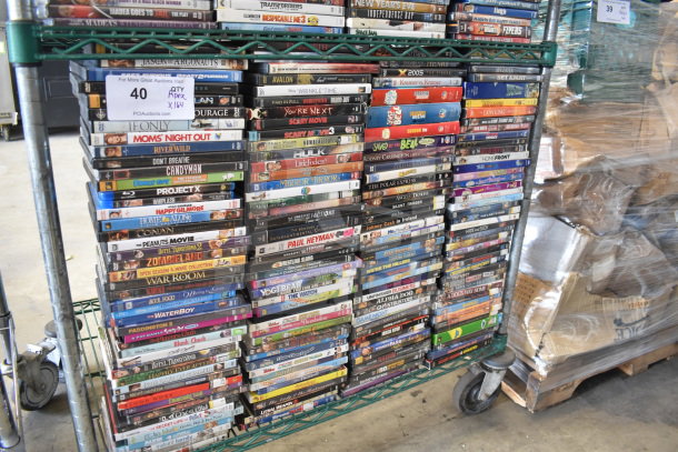 Collection of 164 DVDs on a metal cart, featuring titles like Little Fockers, Polar Express, Lion King, and Saved by the Bell.