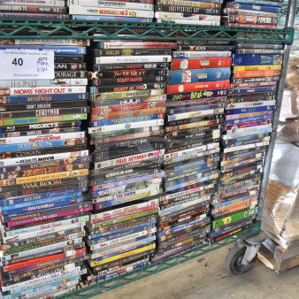 Collection of 164 DVDs on a metal cart, featuring titles like Little Fockers, Polar Express, Lion King, and Saved by the Bell.