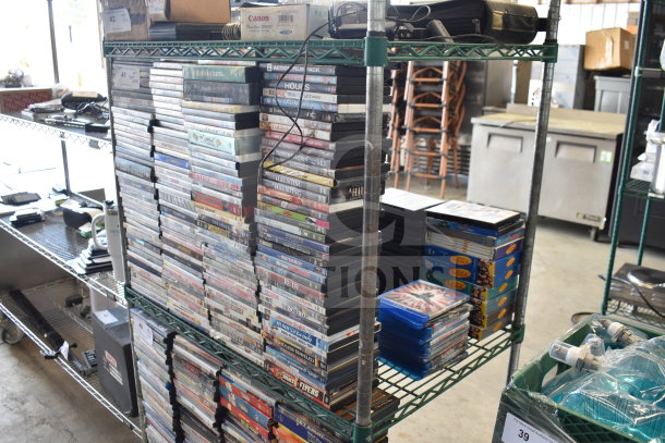 Collection of 340 DVDs on metal shelves, featuring titles like 8 Mile, Catch Me If You Can, and The Simpsons. Used condition.
