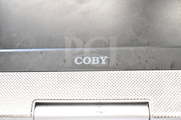 Coby DVD player close-up, showing brand label, silver panel, lightly used condition. Auction includes LG DVD player.